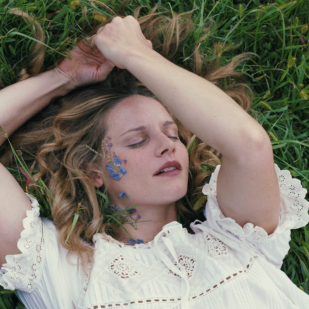 Elly Kace lying in the grass